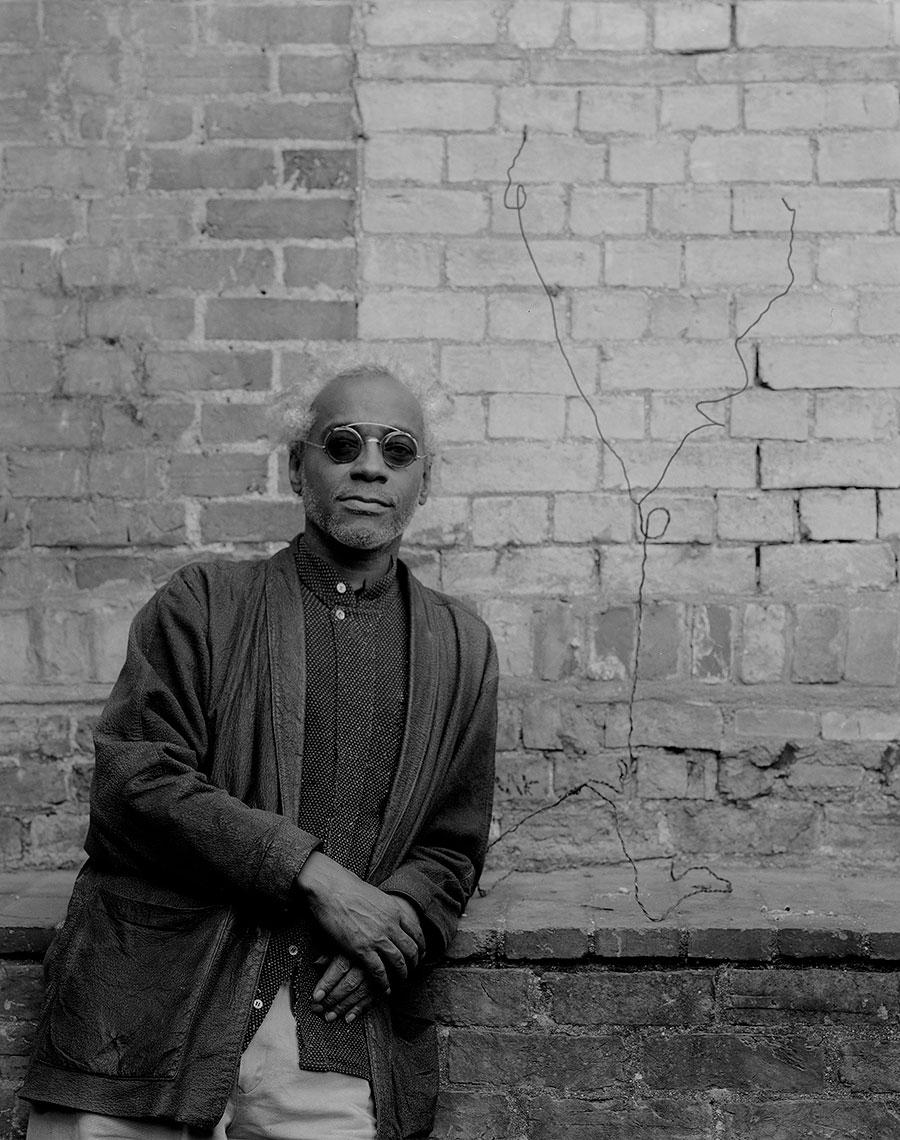 David Hammons posé contre un muret à Kettle's Yard, Cambridge en 1990